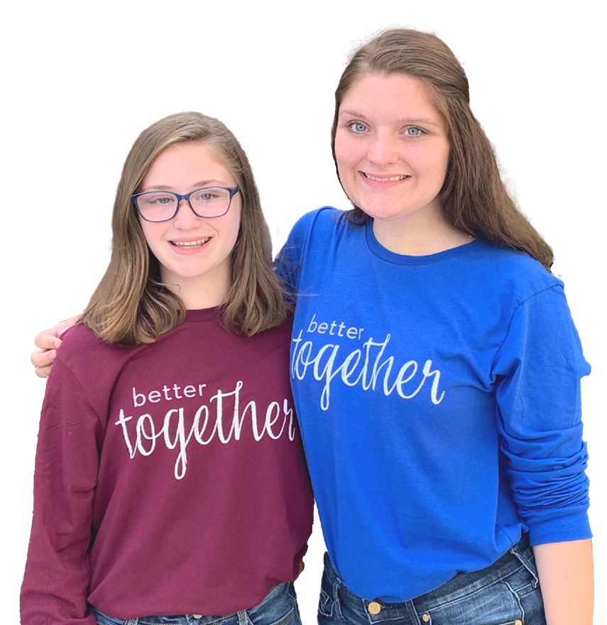Two girls wearing shirts that say 
